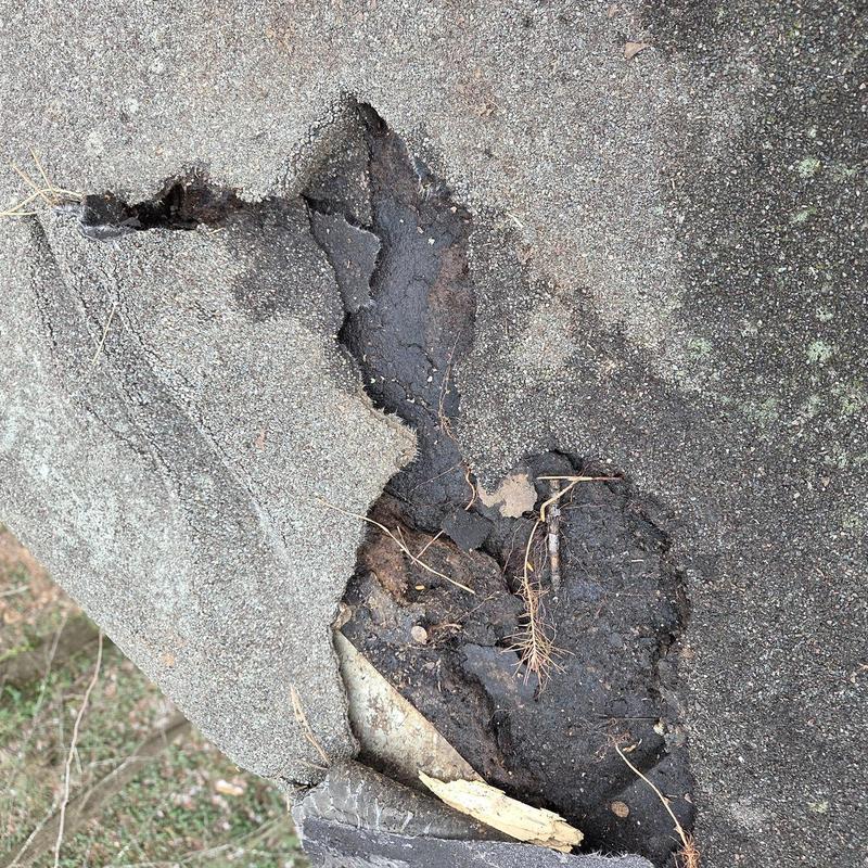 Asphalt roof damaged area with exposed underlayer