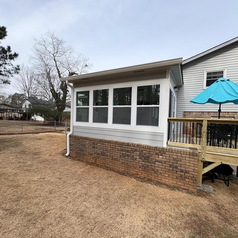 Enclosed patio with attached deck and gutters in Loganville
