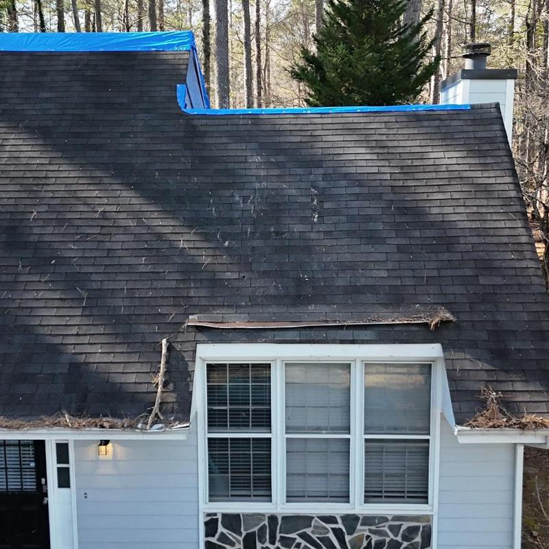 Asphalt shingle roof with tarp and leaf debris