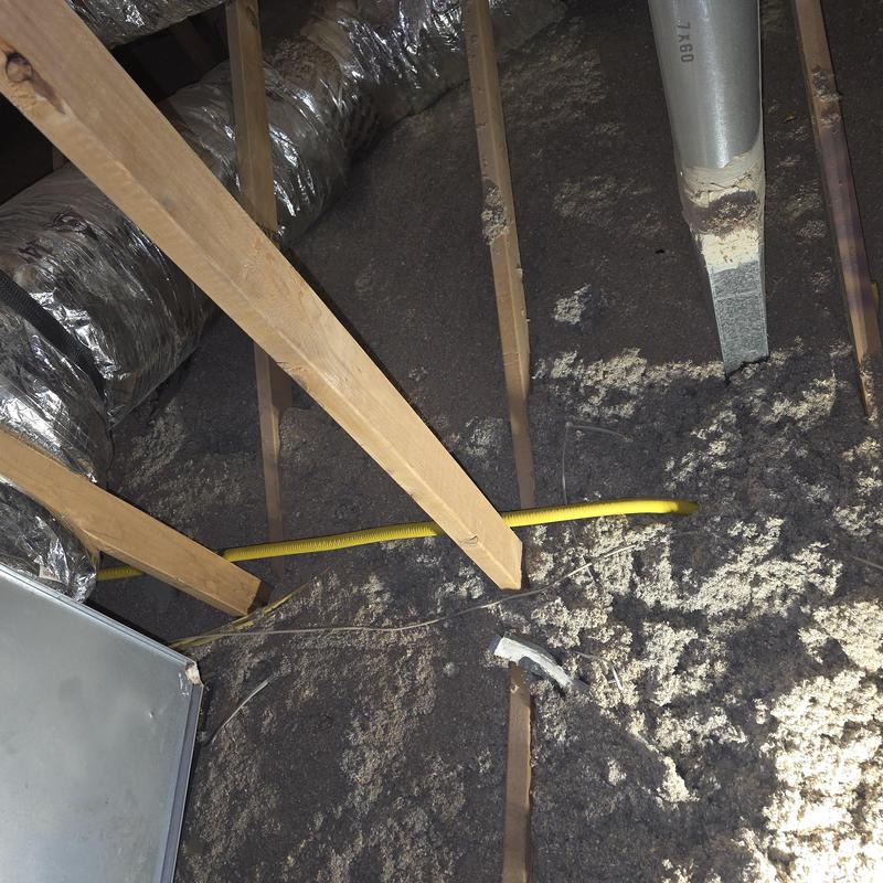 Gas line installation in attic with wooden beams