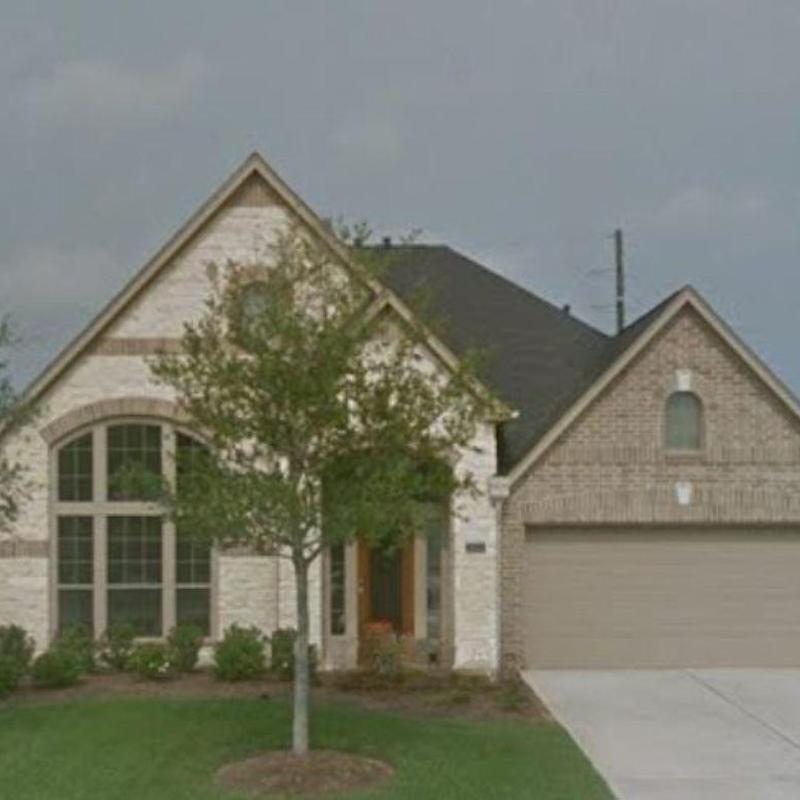Roof shingles and brick exterior with tree in front