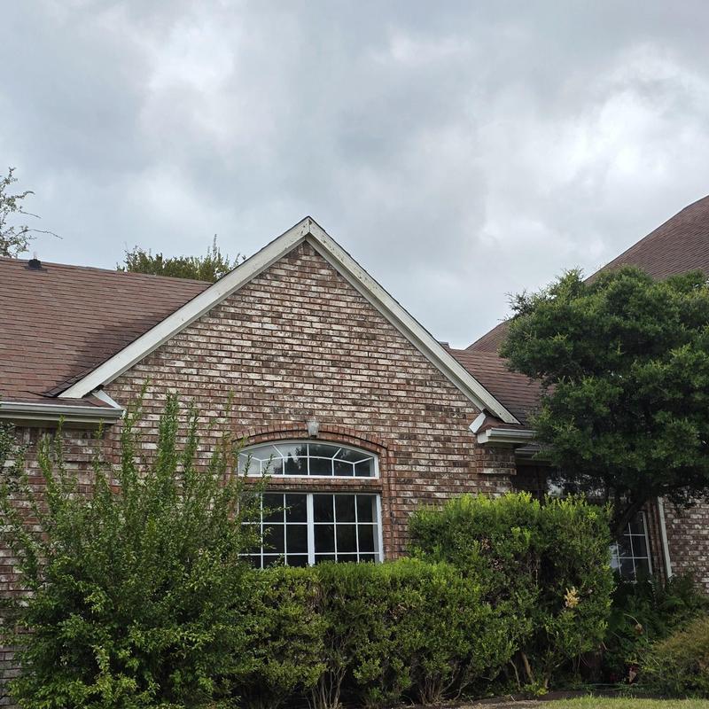 Shingle roof with hail damage on brick house