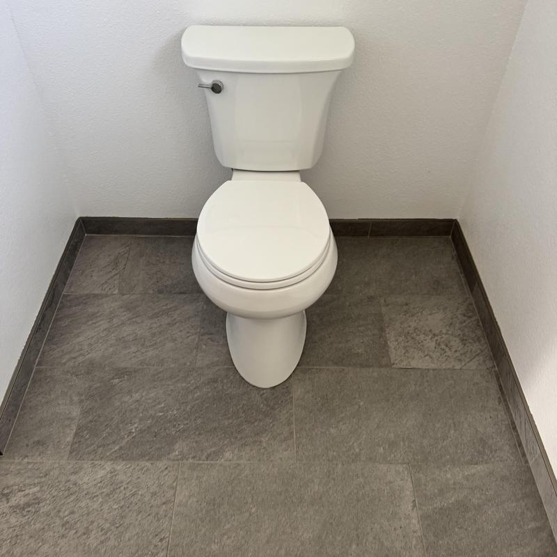 Toilet installation in small tiled bathroom corner