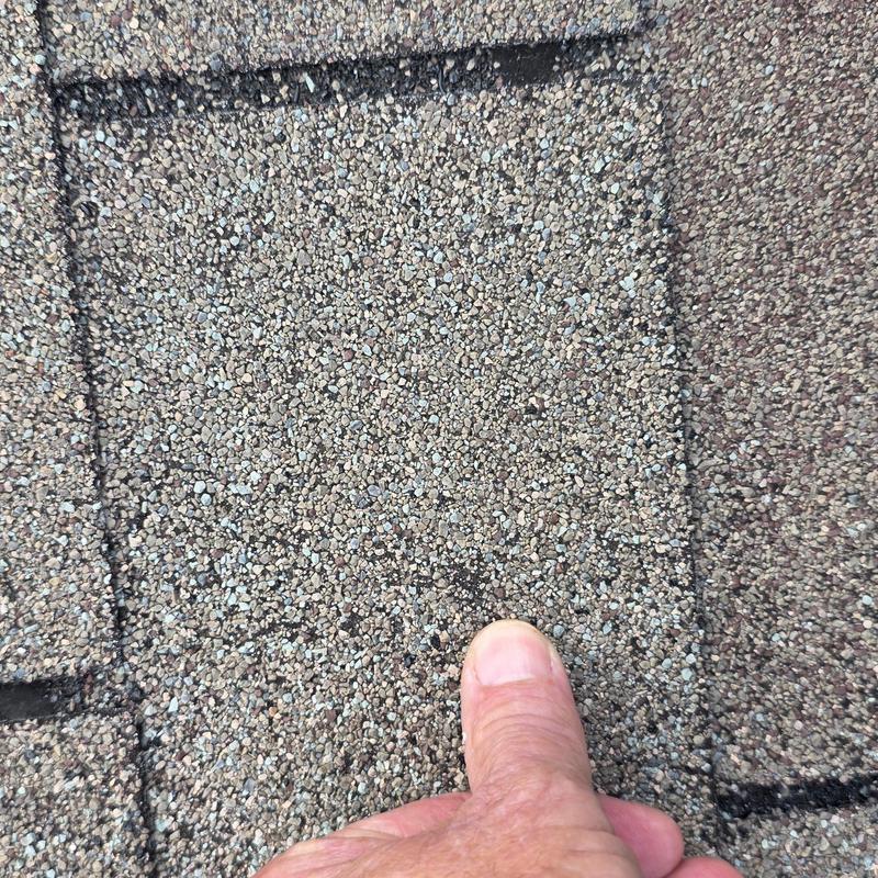 Roof shingles with granule loss and damage near seam