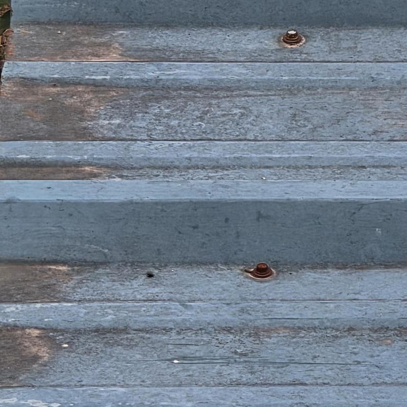 Metal roofing panel with rusted fasteners and stains