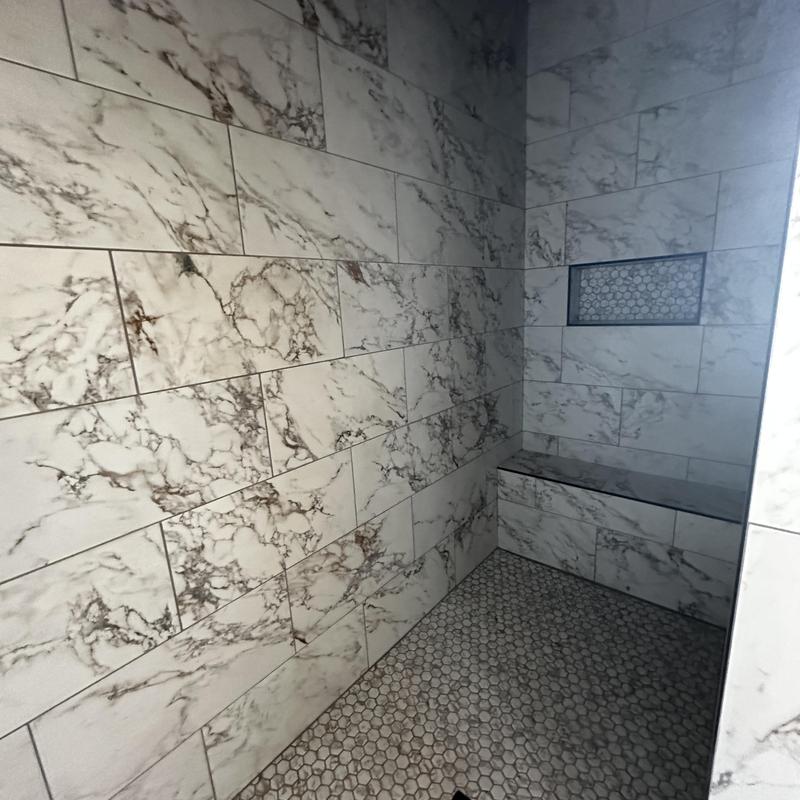 Marble wall tile with hex tile floor in shower Marble wall tile with hex tile floor in shower