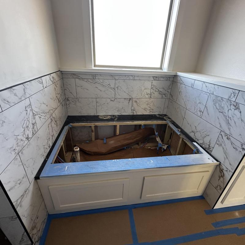 Marble wall tile surrounding bathtub installation in progress Marble wall tile surrounding bathtub installation in progress