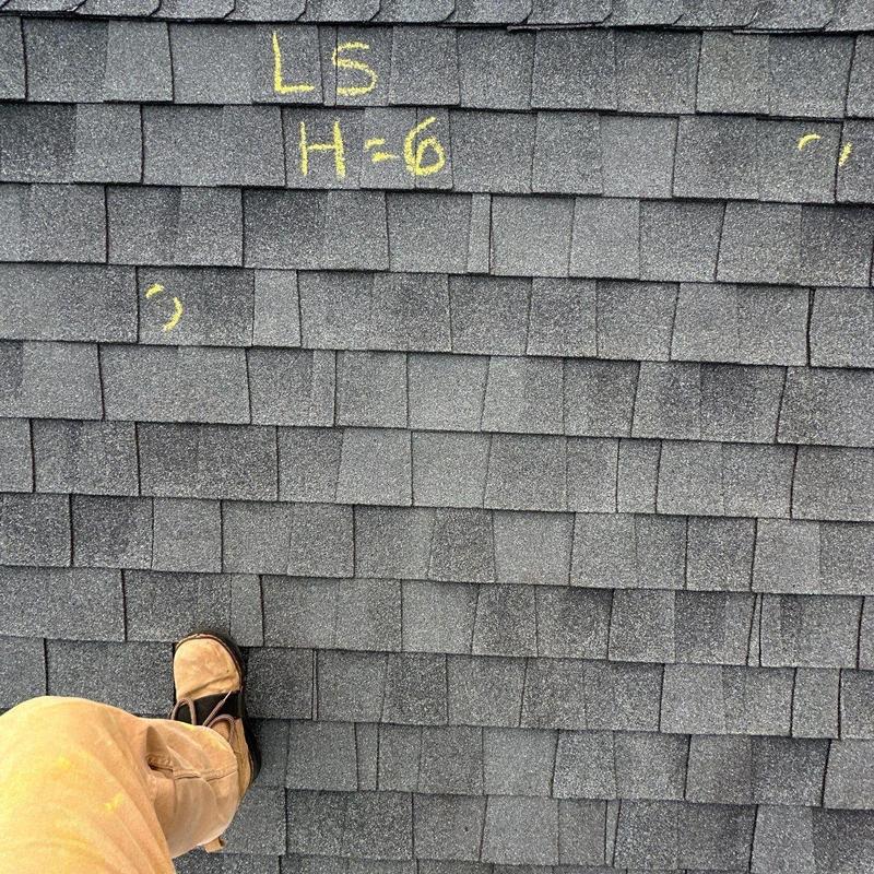 Asphalt shingles with hail damage markings on roof