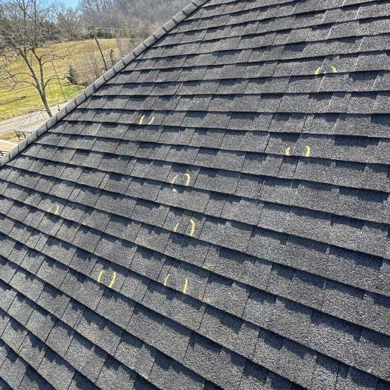 Asphalt shingle roof with hail damage marked in yellow