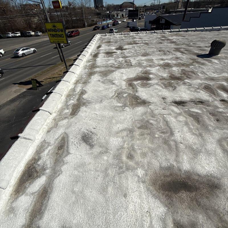 Flat commercial roof with wear and drainage issues