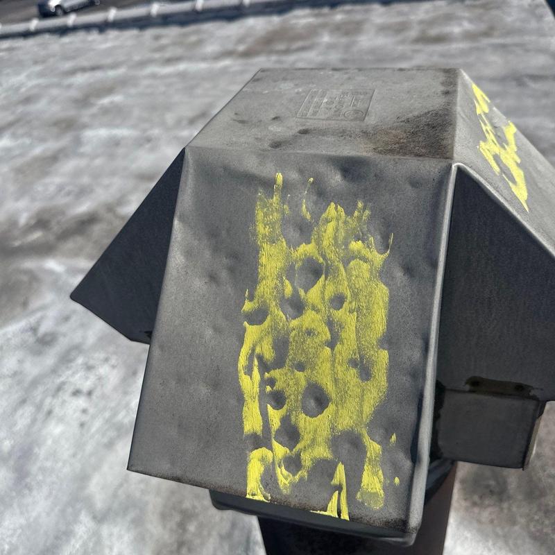 Roof vent cover with hail damage and yellow markings