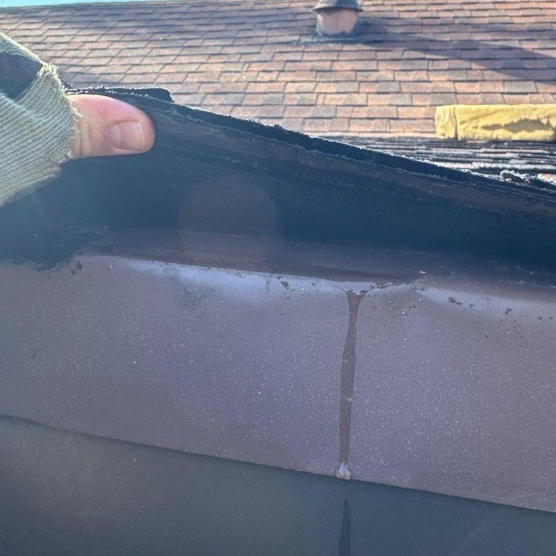 Roof flashing lifted to inspect underlying shingles