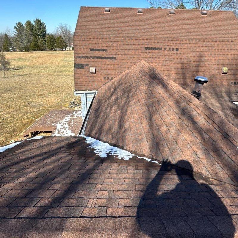 Asphalt shingle roof with hail damage and snow patches
