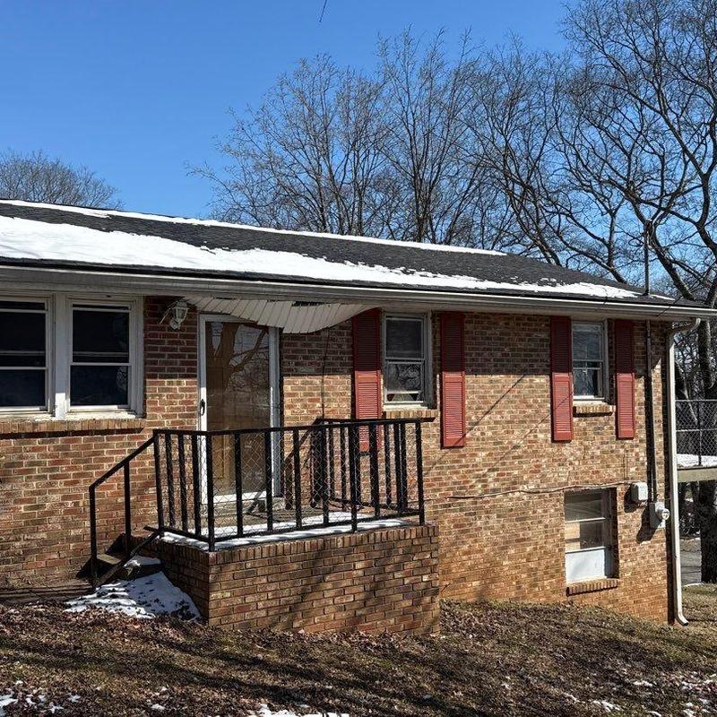 Roof shingles and flashing with hail damage on brick house