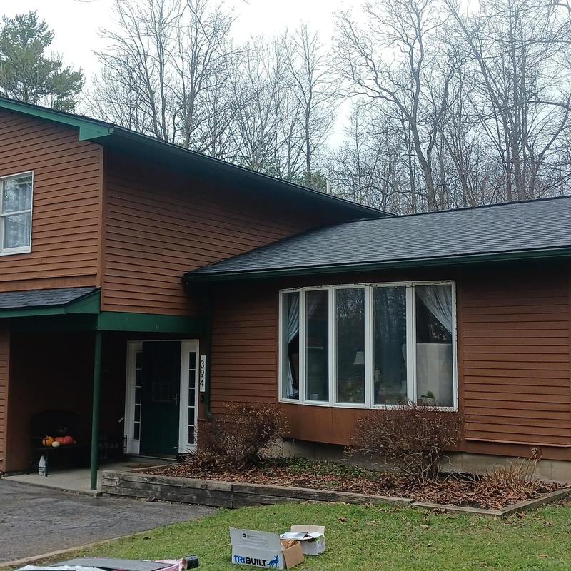 Shingle roof replacement on two-story home exterior