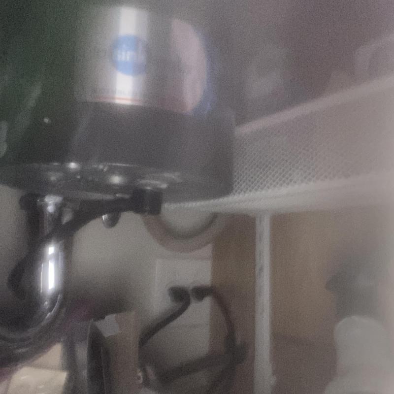 Garbage disposal with removed metal nut under sink