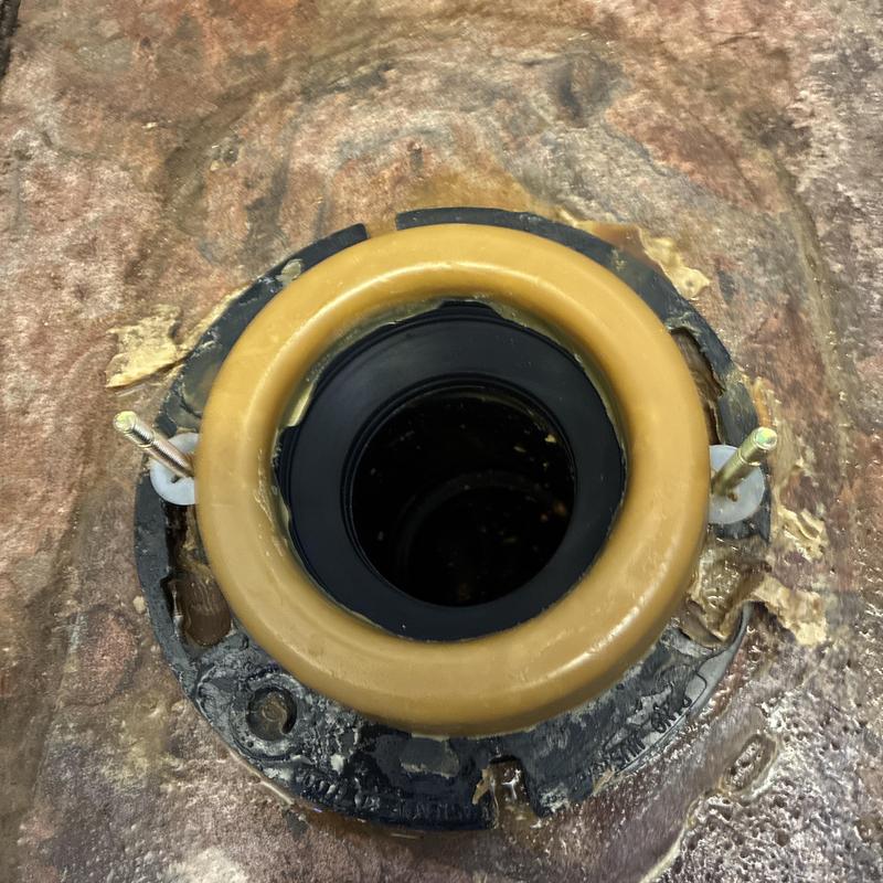 Toilet flange with seal and bolts installed on subfloor