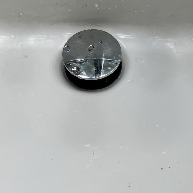 Bathroom sink Kohler pop-up drain assembly with water droplets Bathroom sink Kohler pop-up drain assembly with water droplets