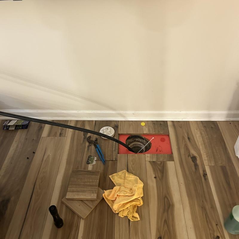 Main sewer line cleanout with plumbing tools and hose