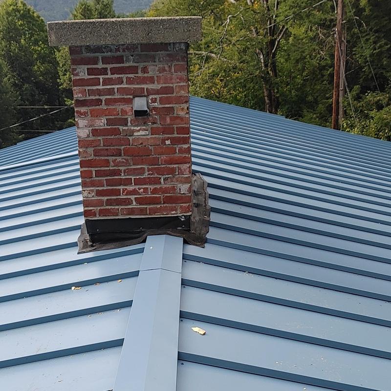 Standing seam metal roof with brick chimney flashing