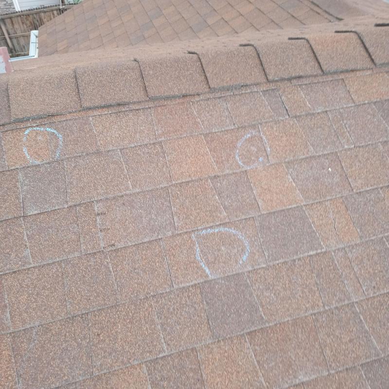 Asphalt shingle roof with hail damage marked in chalk Asphalt shingle roof with hail damage marked in chalk