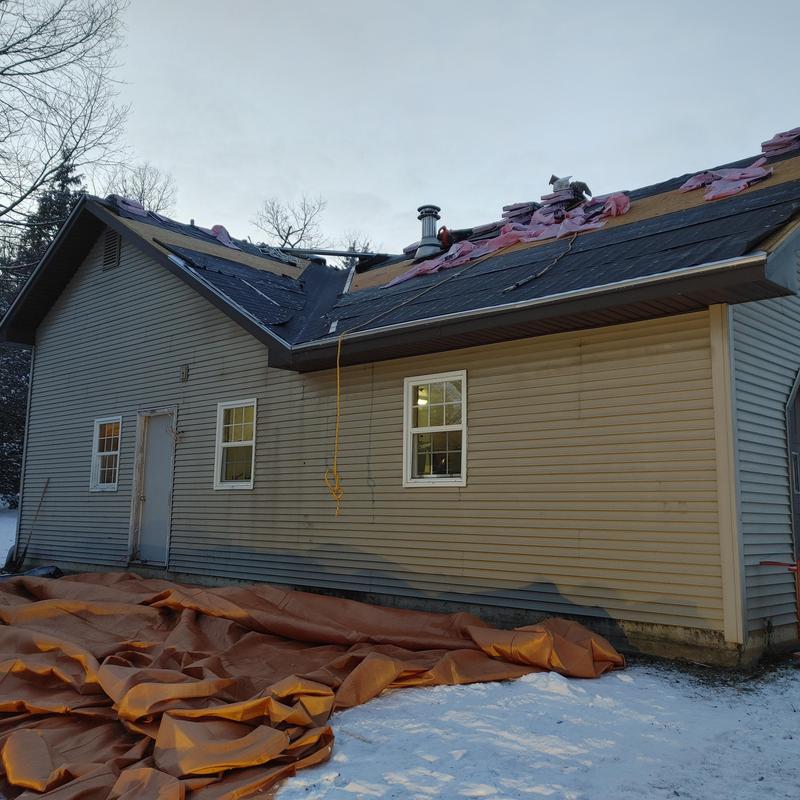 Shingle roof underlayment installation on house in snow