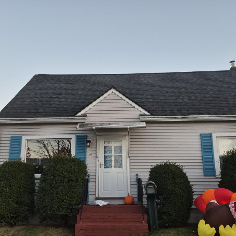 Asphalt shingle roof on beige home with blue shutters