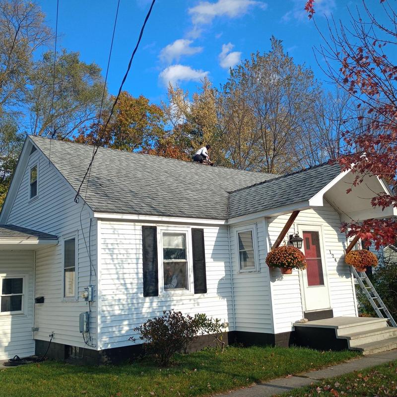 Asphalt shingle roof installation on white home