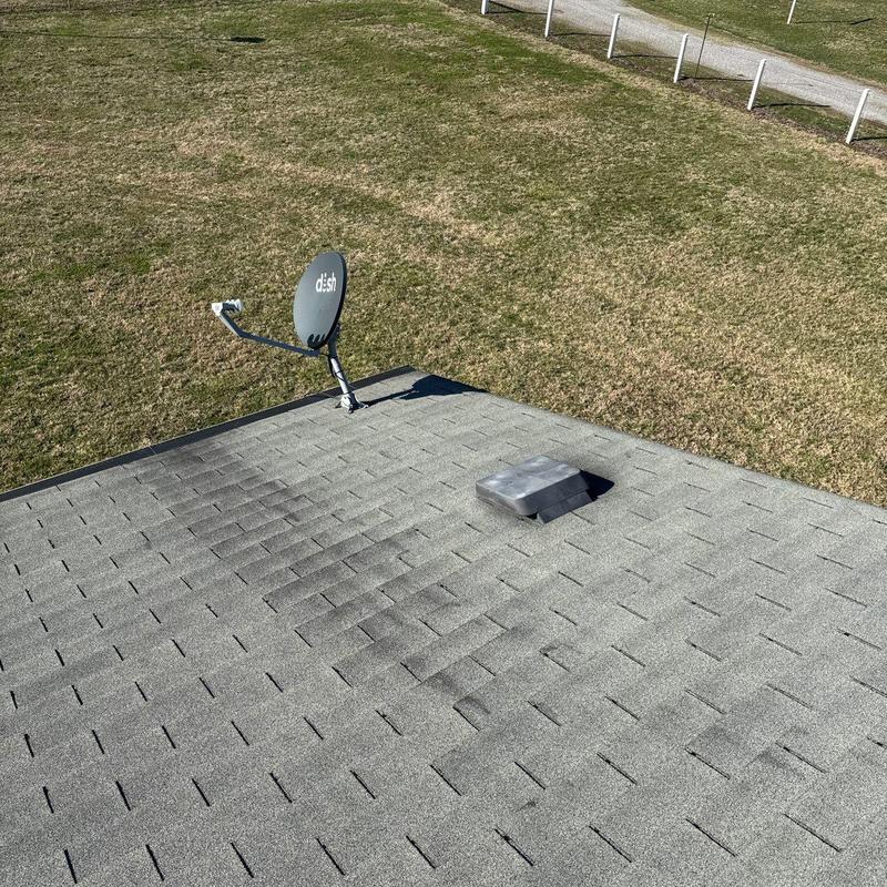 Roof shingles with hail damage near satellite dish and vent