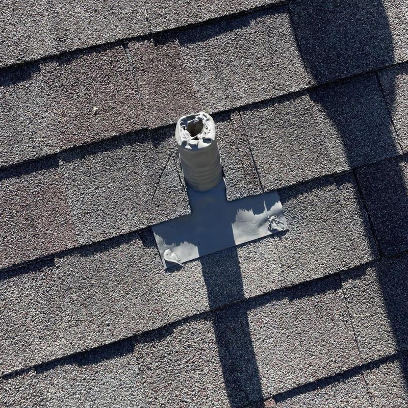 Roof pipe flashing with sealed shingles on asphalt roof