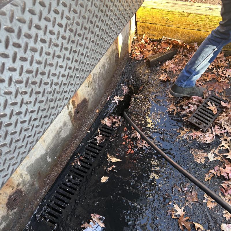 Storm drain grates with leaf and debris cleanup in parking lot