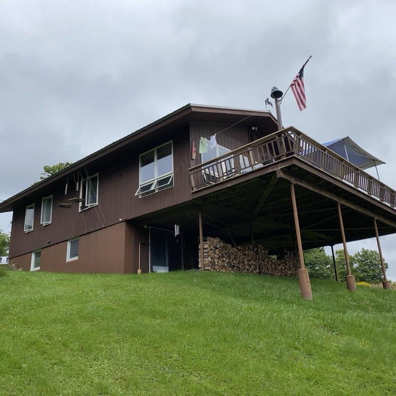 New roof on brown wood-paneled house with deck