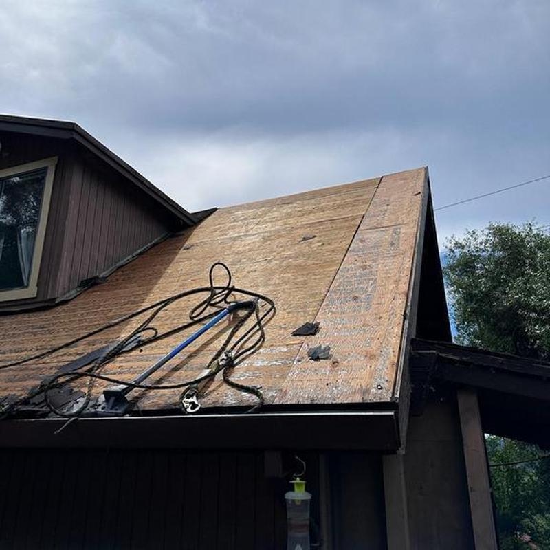 Asphalt roof decking with tools and removed shingles