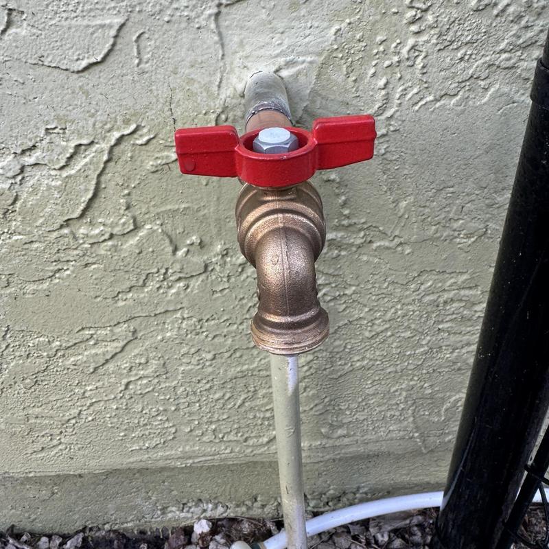Outdoor hose bib with red valve handle installed