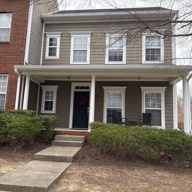 Front porch with concrete steps and shrubbery