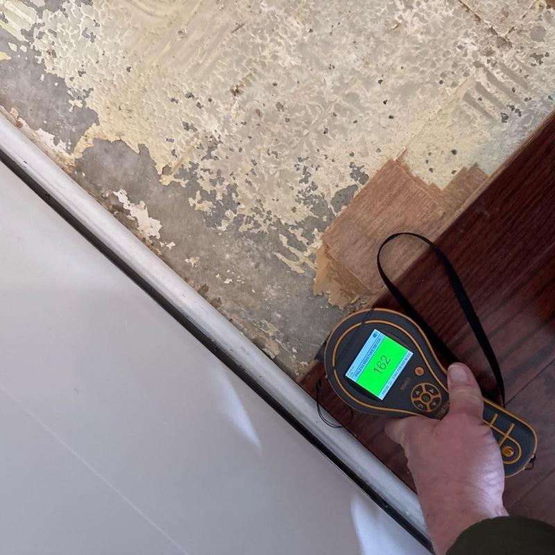 Floor moisture meter reading on damaged flooring