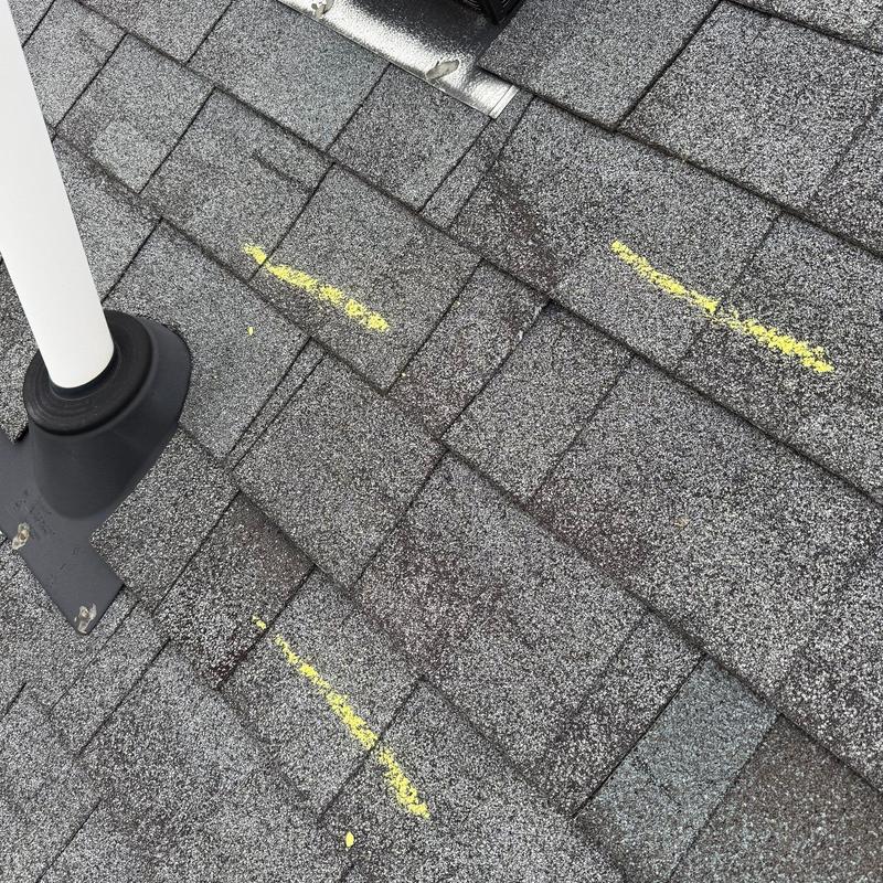 Asphalt shingles with yellow chalk hail damage marks