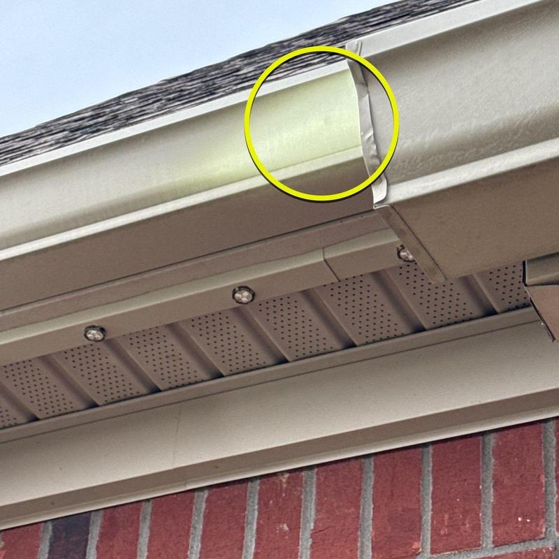 Gutter with dented corner flashing on roof edge