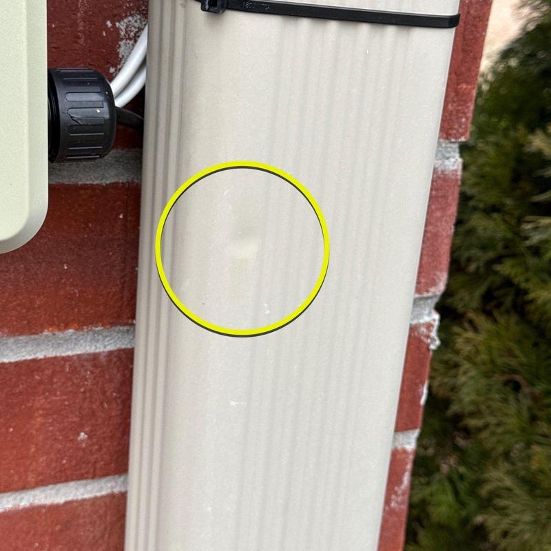 Vinyl siding dent with circled damage on exterior wall