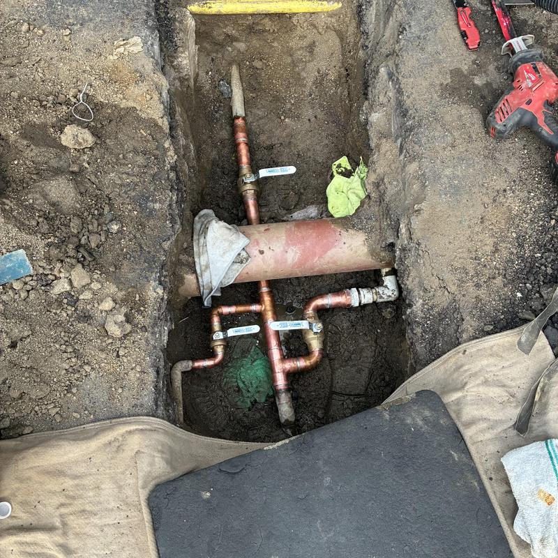 Copper water line with valves in dug trench