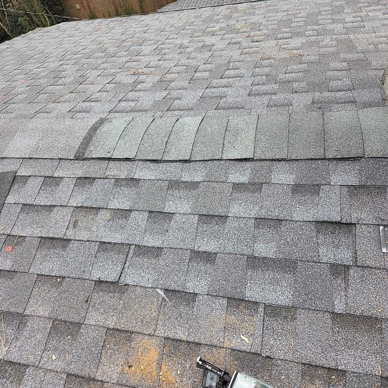 Asphalt roof shingles with replaced ridge caps and caulking