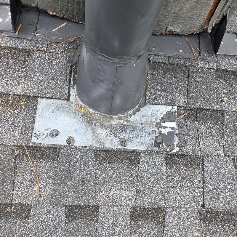 Roof pipe flashing with surrounding shingles and caulking