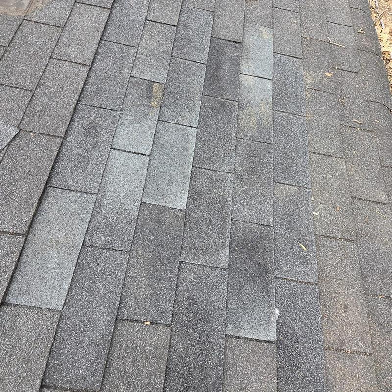Asphalt shingle roof with replaced shingles section