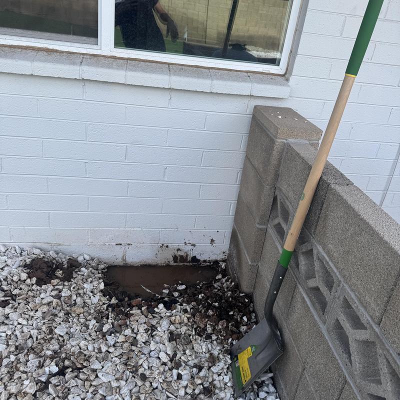 Water main leak excavation in yard near wall