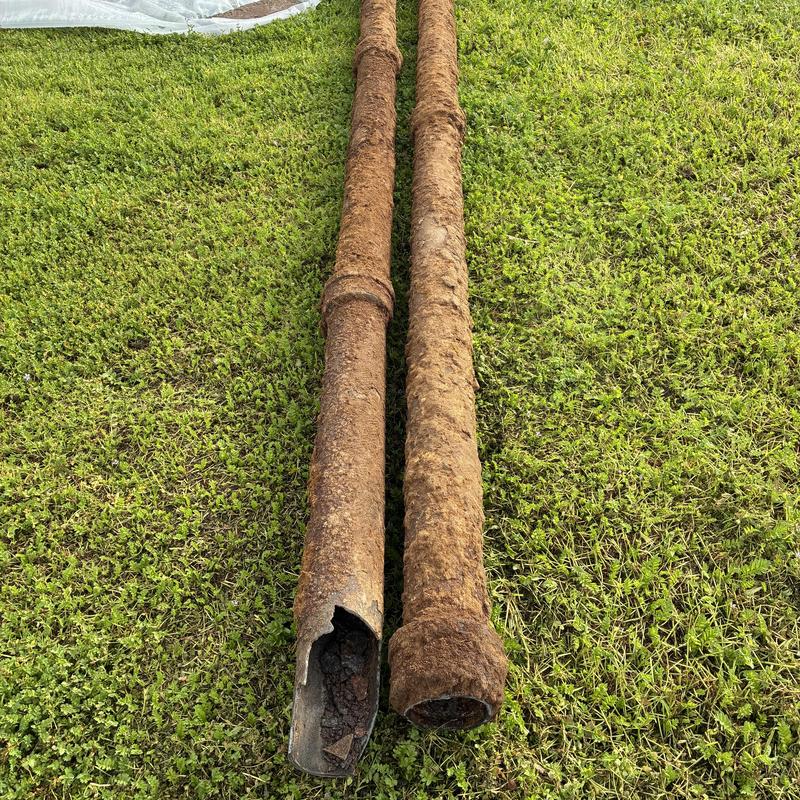 Cast iron sewer pipes rusted and damaged on grass