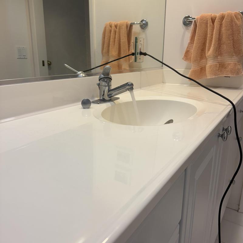 Bathroom sink faucet flow test with drain cleaning cable