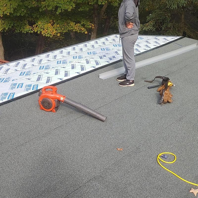 SBS flat roof installation with tools on roof