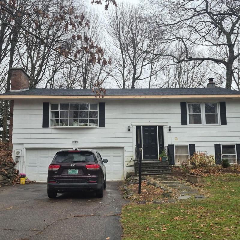 Asphalt shingle roof on white split-level home