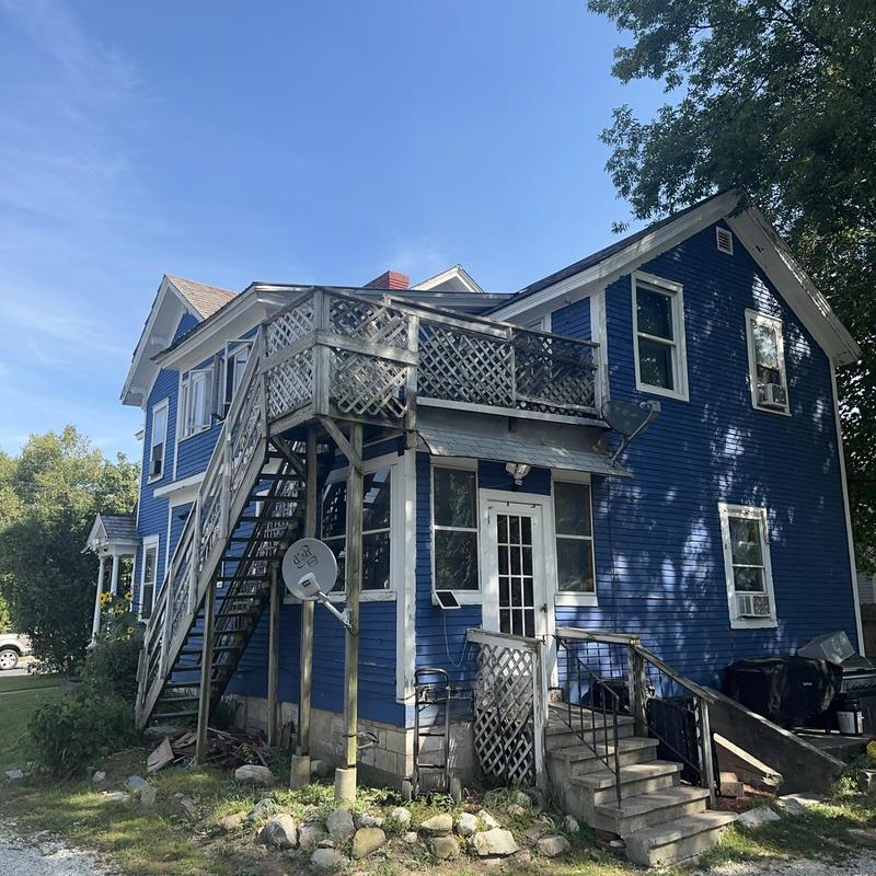 Exterior wooden staircase and balcony on blue house