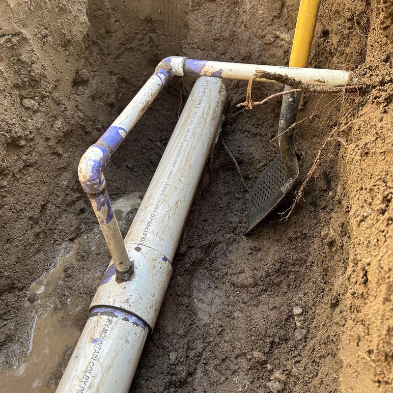 PVC water main pipe with new fittings in soil trench